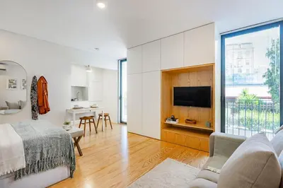 a bedroom with a bed and a couch and a table at Cordoaria City Studio in Porto