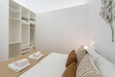 a white room with a bed and two towels at GuestReady - Blueberry Pie in the Balcony in Porto
