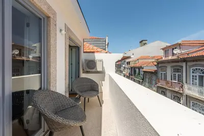 two chairs sitting on the balcony of a building at GuestReady - Blueberry Pie in the Balcony in Porto