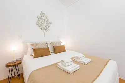 a bedroom with a white bed with towels on it at GuestReady - Blueberry Pie in the Balcony in Porto