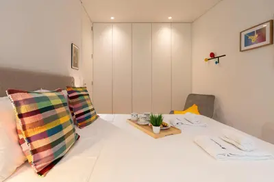 a room with a bed with a table and a chair at Host Wise - Stylish Urban Flat with Terrace in Porto