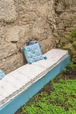 a mattress sitting in front of a stone wall at Host Wise - Stylish Urban Flat with Terrace in Porto