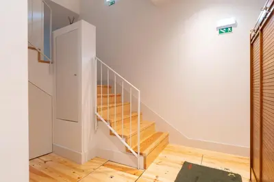 a staircase in a home with white walls and wooden floors at Host Wise - Stylish Urban Flat with Terrace in Porto