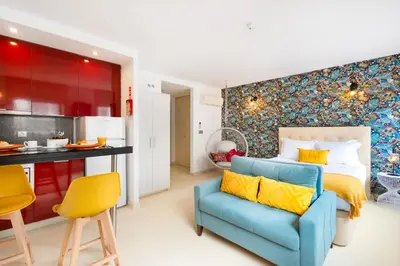 a bedroom with a blue couch and a kitchen at Boavista Loft in Porto