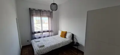 a small room with a bed and a window at Leote in Porto