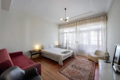 a bedroom with a bed and a couch and a window at A Casa Formosa in Porto