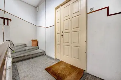 a white door in a hallway with stairs at A Casa Formosa in Porto