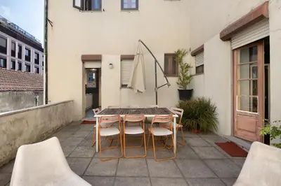 a patio with a table and chairs and a umbrella at A Casa Formosa in Porto