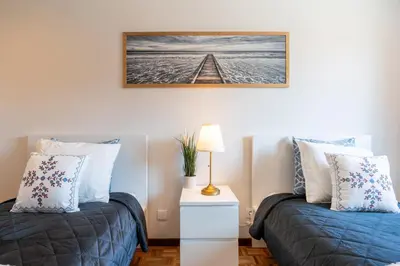 a bedroom with two beds and a picture on the wall at Host Wise - Bright and Elegant Urban Flat with Balcony in Porto
