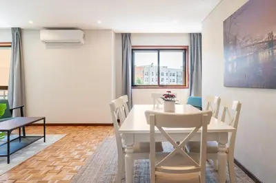 a dining room with a white table and chairs at Host Wise - Bright and Elegant Urban Flat with Balcony in Porto