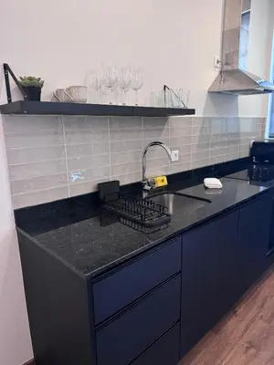 a kitchen with a black counter top with wine glasses at River Apartment in Porto
