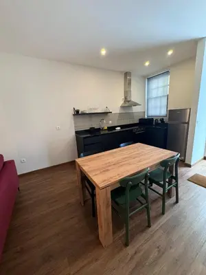 a kitchen with a wooden table and green chairs at River Apartment in Porto
