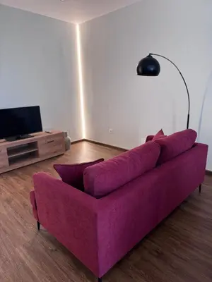 a purple couch in a living room with a tv at River Apartment in Porto