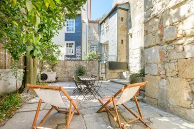two chairs and a table in a courtyard at GuestReady - Historic Courtyard Townhouse in Porto