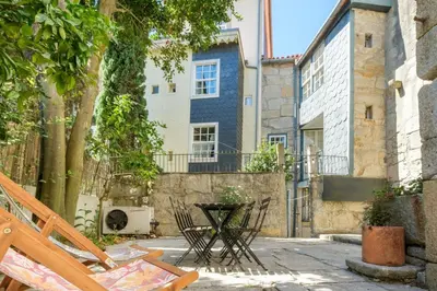 a white bedroom with a bed and a window at GuestReady - Historic Courtyard Townhouse in Porto