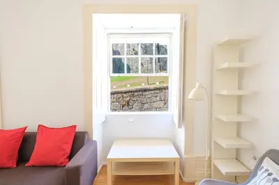 a table and chairs in front of a stone building at GuestReady - Historic Courtyard Townhouse in Porto