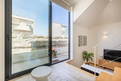 a living room with yellow chairs and a staircase at Duque de Saldanha Duplex Loft in Porto