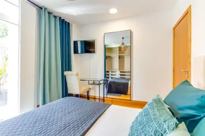 a bedroom with a bed and a mirror at Cozy Nest in Porto