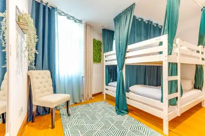 a bedroom with two bunk beds and a chair at Cozy Nest in Porto