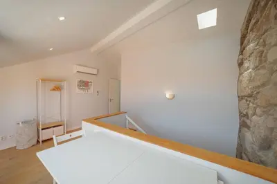 a room with a staircase with a stone wall at Alegria Duplex by Hosty in Porto