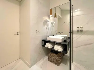 a white bathroom with a sink and a shower at Essência Portuense Studios in Porto