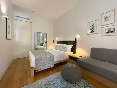 a hotel room with a bed and a couch at Essência Portuense Studios in Porto