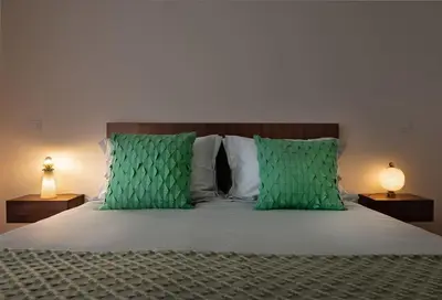 a bedroom with a bed with green pillows and two lamps at Take me to Aliados in Porto
