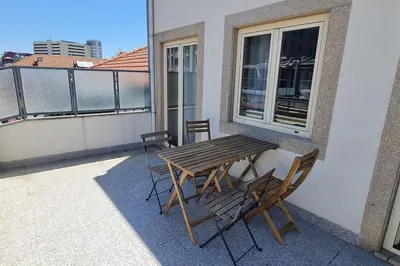 a wooden table and chairs on a balcony at Tomás FLAT 4F in Porto