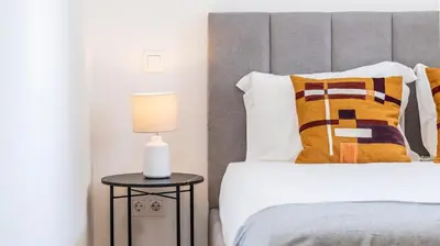 a bedroom with a bed and a side table with a lamp at Infante Studio w Parking by LovelyStay in Vila Nova de Gaia