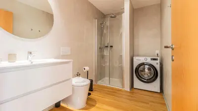 a bathroom with a sink and a washing machine at Infante Studio w Parking by LovelyStay in Vila Nova de Gaia