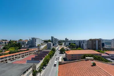 a large glass building with a car parked in front at DoisPontoZero Júlio Dinis Gold in Porto