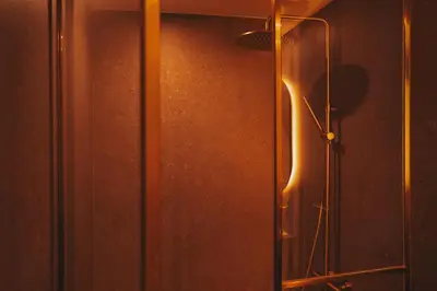 a glass shower door with a light on the wall at Domum 4 in Porto
