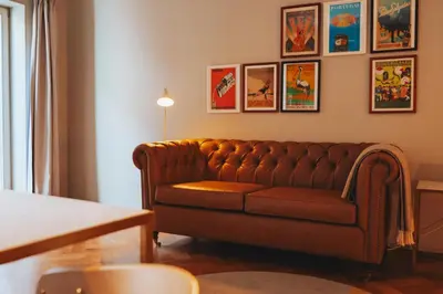 a brown couch in a living room with pictures on the wall at Domum 4 in Porto