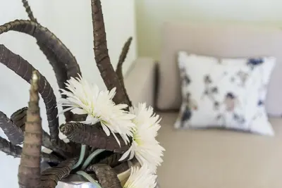 a vase with white flowers in a room with a pillow at GuestReady - Lightform Apartment in Porto
