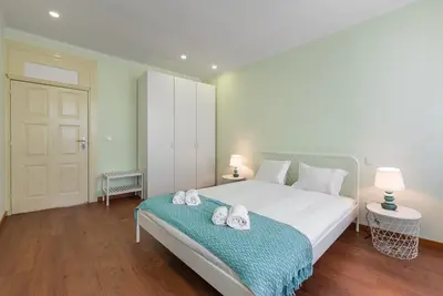 a bedroom with a large white bed with towels on it at GuestReady - Lightform Apartment in Porto