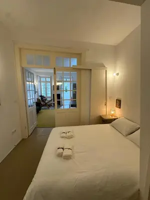 a bedroom with a large white bed with towels on it at Aliados Historic Downtown Apartments by LuxiStay in Porto