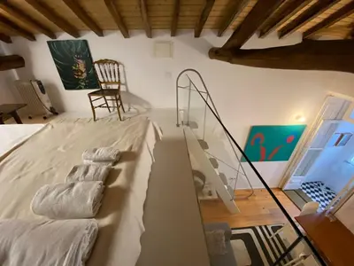 a room with a bed with a chair and a staircase at Aliados Historic Downtown Apartments by LuxiStay in Porto