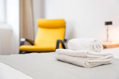 a pile of towels on a counter with a yellow chair at GuestReady - Serene Hideout in Downtown in Porto