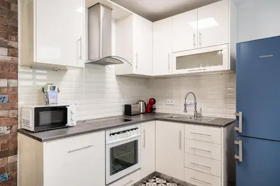 a kitchen with white cabinets and a sink and a microwave at GuestReady - Serene Hideout in Downtown in Porto