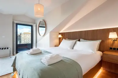 a bedroom with a large bed with towels on it at Aires Gouveia Penthouse in Porto
