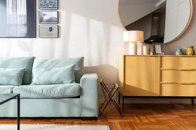 a living room with a blue couch and a yellow dresser at Aires Gouveia Penthouse in Porto