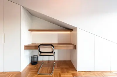 a chair sits in a room under a staircase at Aires Gouveia Penthouse in Porto