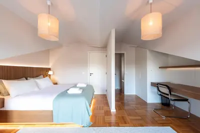 a bedroom with a bed with a blue blanket and two lights at Aires Gouveia Penthouse in Porto
