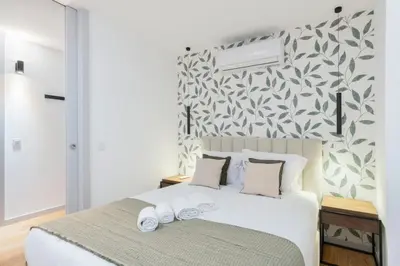 a bedroom with a large white bed with a patterned wall at GuestReady - Tranquil haven in the city centre in Porto