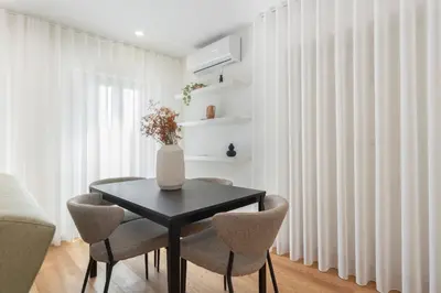 a dining room with a black table and chairs at GuestReady - Tranquil haven in the city centre in Porto