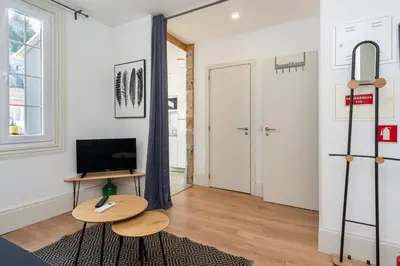 a living room with a table and a television at GuestReady - Le Jardin Secret in Porto
