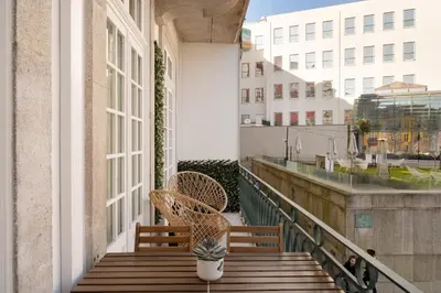 a balcony with two chairs sitting on a porch at 42 1T Cardosas Block Historic Ap in Porto