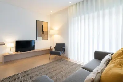 a living room with a couch and a television at GuestReady - Modern 2-Bedroom Apt in Cedofeita in Porto
