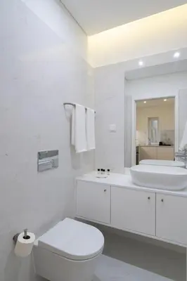 a white bathroom with a toilet and a sink at GuestReady - Modern 2-Bedroom Apt in Cedofeita in Porto