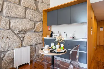 a bedroom with a stone wall and a bed at GuestReady - Porto de Rio Residences in Porto